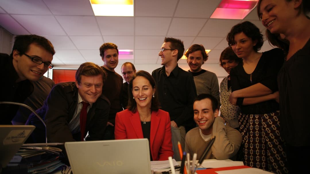 Team of digital specialists collaborating around a laptop computer in an office