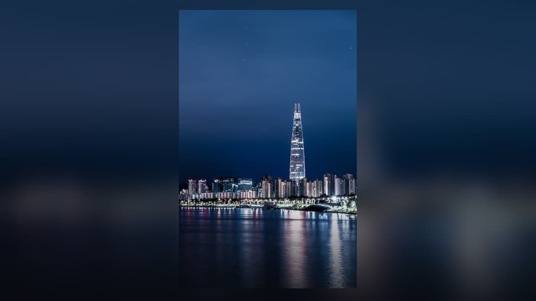 Lotte World Tower illuminated against the nighttime skyline of Seoul.