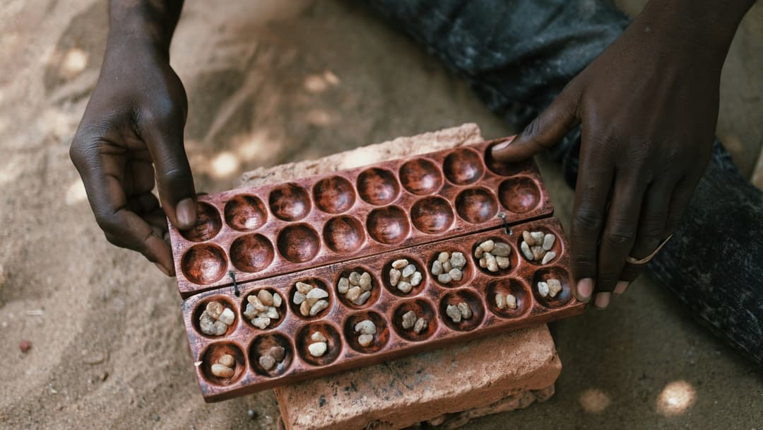 Carved wooden Mancala board filled with seeds