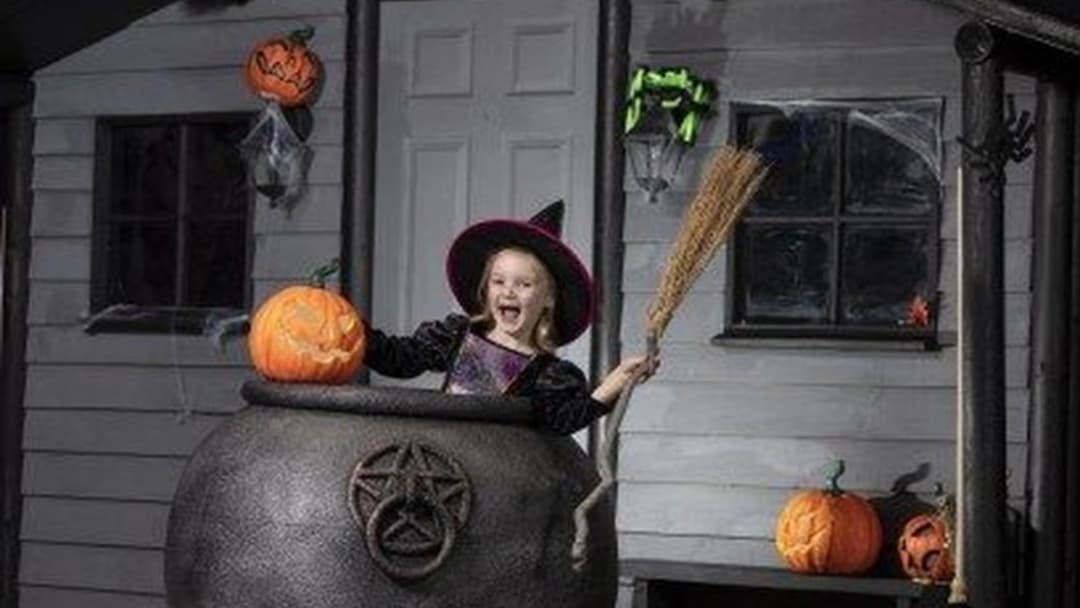 Traditional straw witch broomstick beside hearth and cauldron