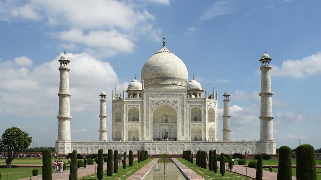 Symmetrical front view of the Taj Mahal reflecting in the garden pool