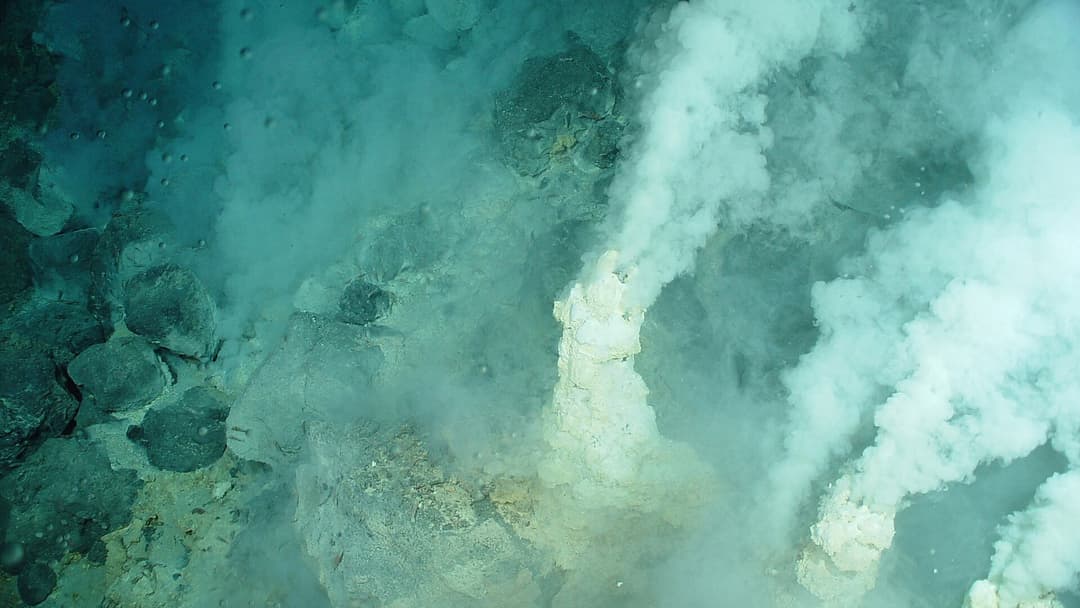 Active hydrothermal chimneys venting shimmering fluids on the Mariana slope.