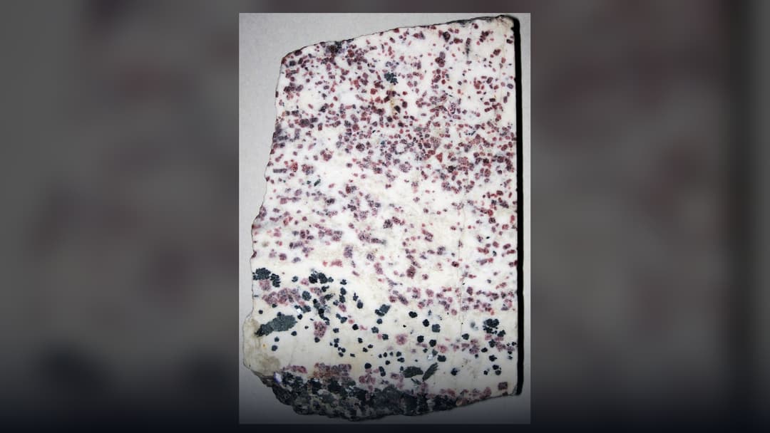 Vivid crimson crystalline eudialyte rare earth mineral in host rock from South Greenland.