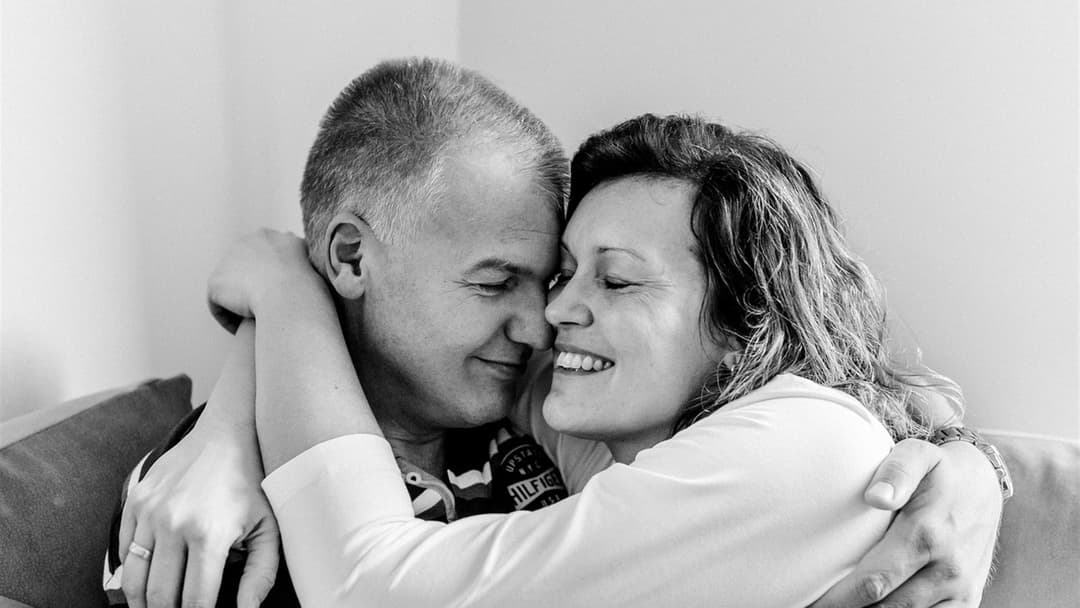 Long-term couple embracing calmly and co-regulating stress and endocrine balance at home