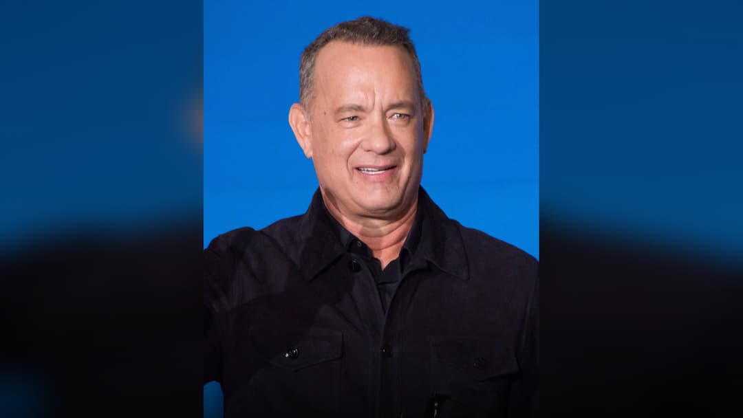 Tom Hanks smiling at a film premiere.