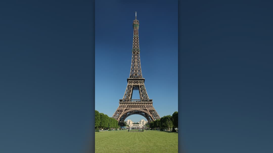 Full vertical view of the Eiffel Tower rising above Paris