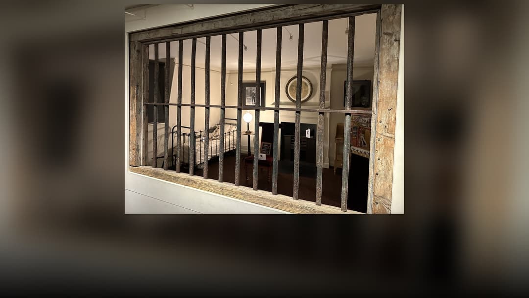 Heavy iron prison bars inside a maximum-security lockup.