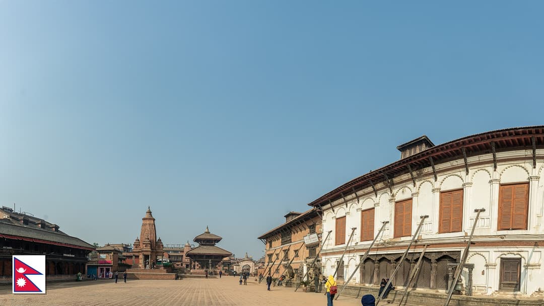 Historic temples of Bhaktapur Durbar Square in the Kathmandu Valley, Nepal with the Nepali flag in the bottom left corner