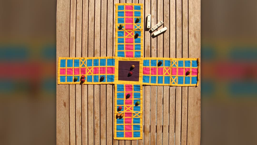 Traditional Indian embroidered cloth Pachisi board with markers and cowrie shells