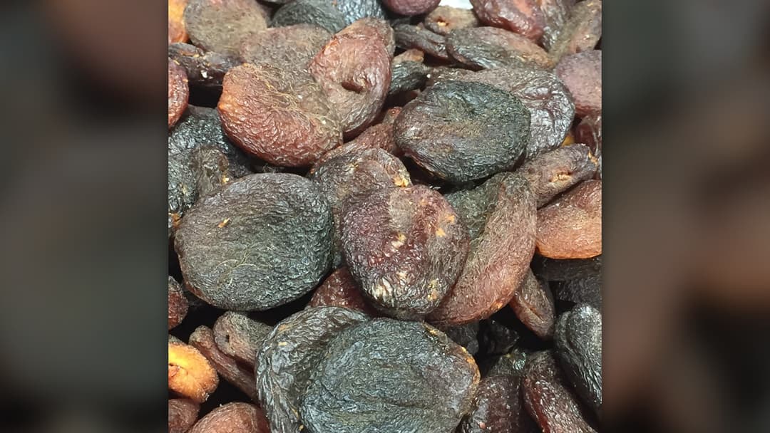 Close-up of dark brown sun-dried Turkish apricots piled together.
