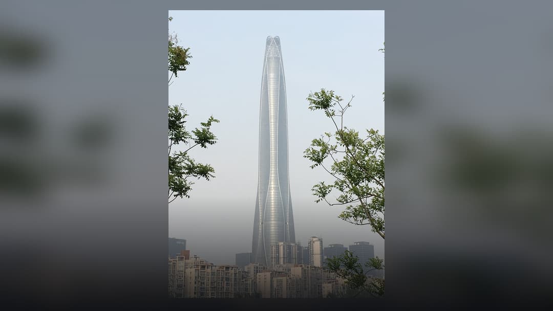 The curved glass facade of the Tianjin CTF Finance Centre rising into the sky.