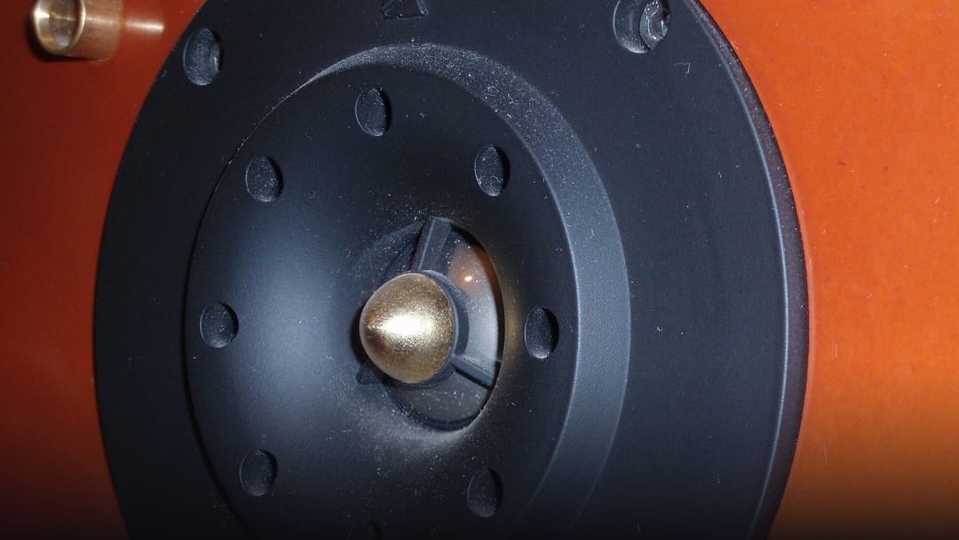 Macro close-up of a precision electroacoustic micro-speaker transducer and directional acoustic driver.