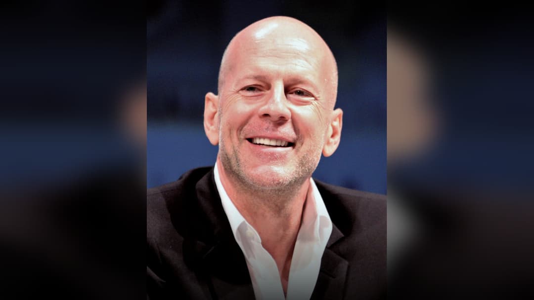 Bruce Willis smiling at a premiere event.