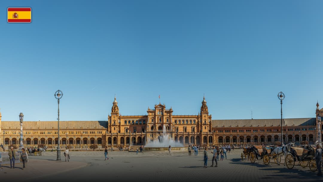 The grand Renaissance and neo-Moorish palace, towers, and fountain of Plaza de España in Seville, with the flag of Spain.