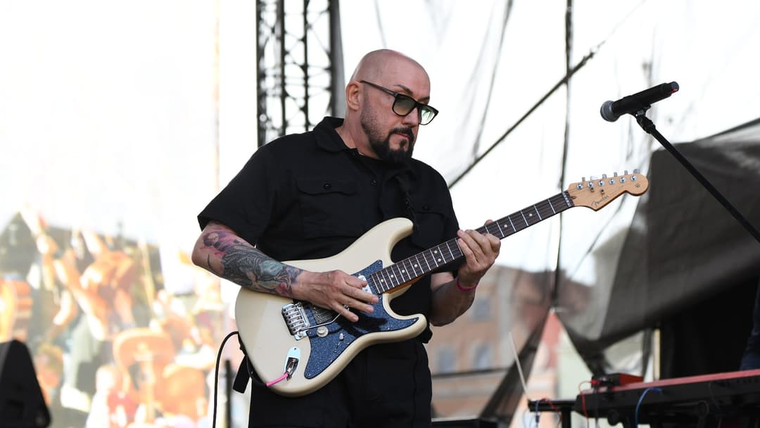 Musician playing electric guitar in energetic live concert