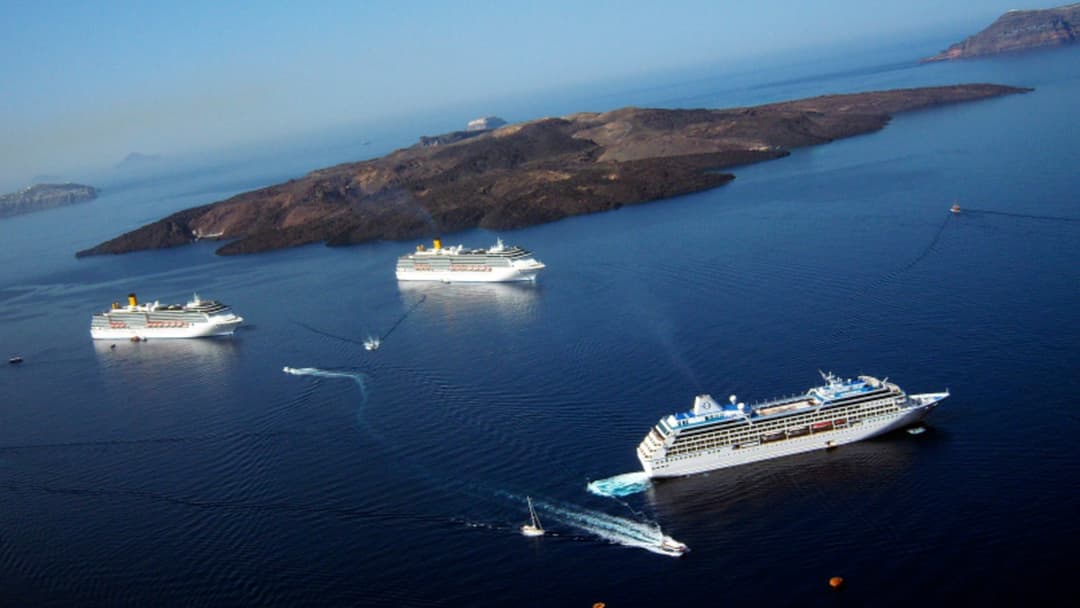 Aerial view of the dark volcanic island of Nea Kameni inside the flooded Santorini caldera in Greece.
