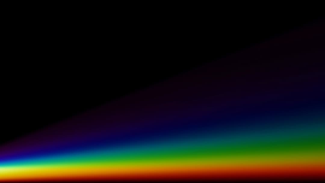 An optical glass prism dispersing a beam of light into the full visible spectrum.