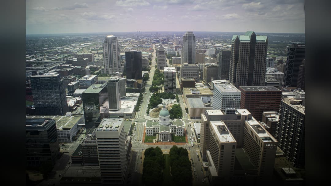 The iconic Gateway Arch soaring over the downtown St. Louis Missouri skyline at sunset.
