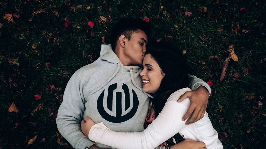 Affectionate couple embracing closely and sharing skin-to-skin contact outdoors