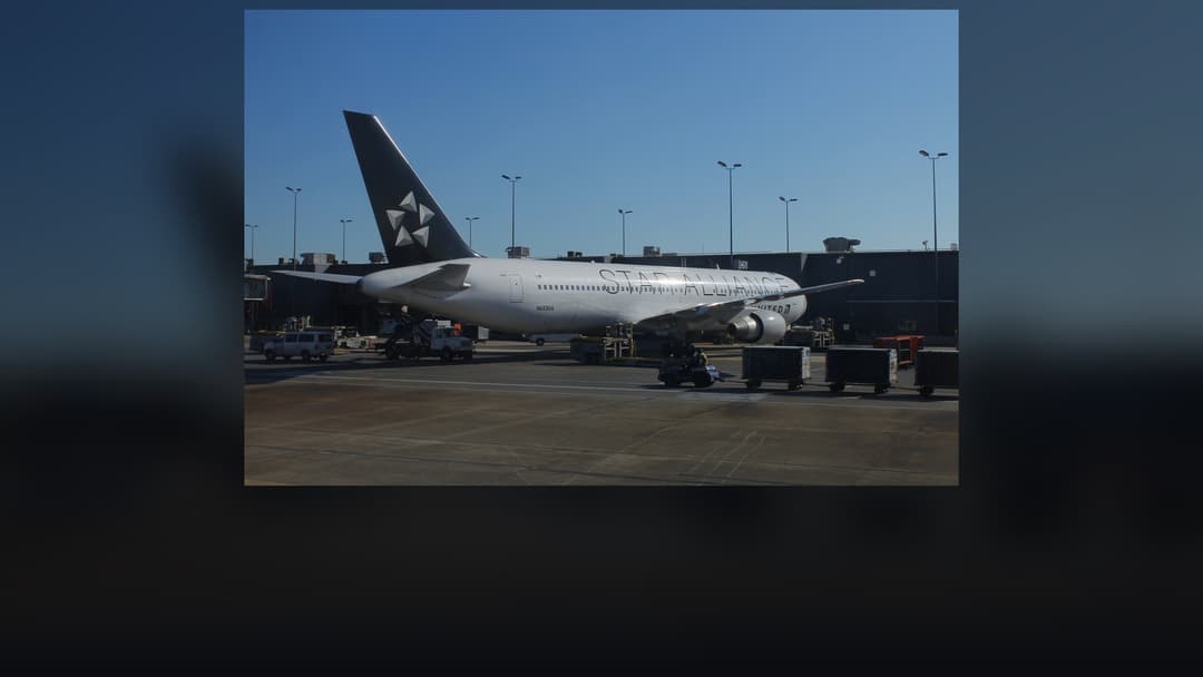 United Airlines Boeing 767 wide-body aircraft banking during flight with blue and white tail markings.