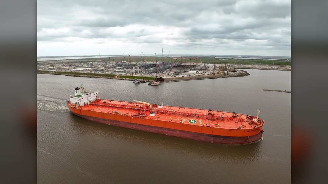 Aerial view of the red-decked crude oil tanker Eagle Kinabalu underway in a shipping channel.